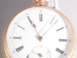 a gold pocket watch with roman numerals on it
