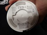 a person holding a white smoke detector in their hand