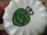 quelqu'un tient une petite assiette blanche sur laquelle est collée une étiquette verte