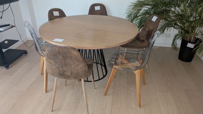 une table et des chaises dans une pièce où se trouve une plante
