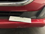 the front bumper of a red car with a sticker on it ' s bumper