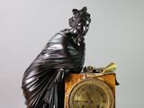 a statue of a woman sitting on top of a clock