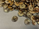 a pile of gold buttons sitting on a table