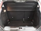 the back of a red car with its trunk open and the back seats folded down