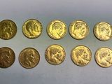 un tas de pièces d'or posé sur une surface blanche