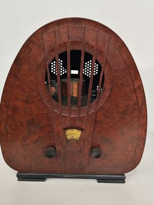 une radio à l'ancienne avec un boîtier en bois posée sur une surface blanche