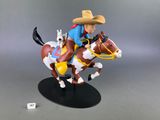 toy figurine of a cowboy riding a horse with a cat on his back