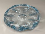 un saladier en verre transparent bordé de bleu, posé sur une table