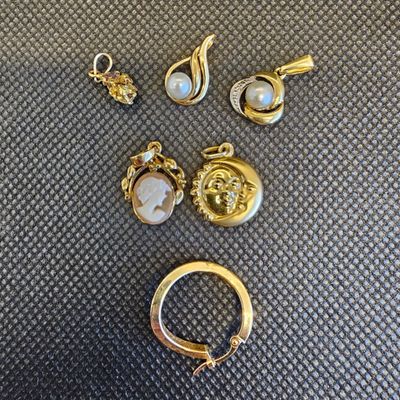 une collection de bijoux en or et en perles, comprenant une bague, des boucles d'oreilles et un pendentif