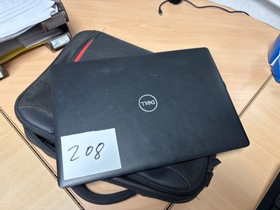 a dell laptop sitting on top of a bag on a desk