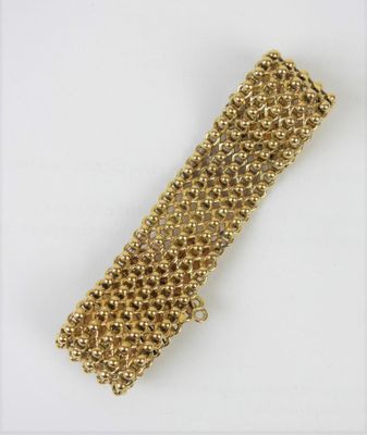 a close up of a gold bracelet on a white surface