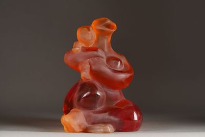 a red and orange gummy bear sitting on a white surface
