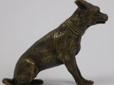 statue of a dog sitting on its hind legs with a collar around it ' s neck