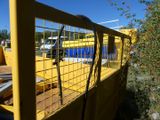 a yellow truck that is parked next to a fence