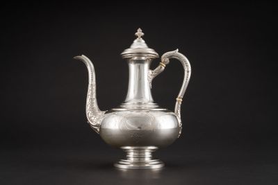 une cafetière en argent avec une anse, sur fond noir