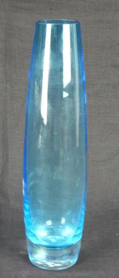 a blue glass vase sitting on a gray surface