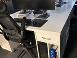 un bureau avec deux écrans d'ordinateur et une chaise placée devant
