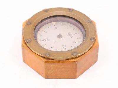 une petite horloge posée sur une surface blanche