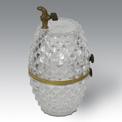 an image of a glass jar with a brass handle on a grey background