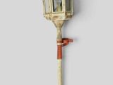 une petite lampe fixée à un poteau sur un mur