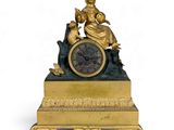 a gold clock with a statue on top of it