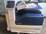 a printer that is sitting on the ground next to a chair
