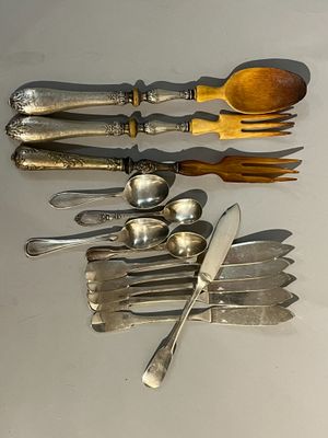 Plusieurs cuillères et fourchettes sont alignées sur une table