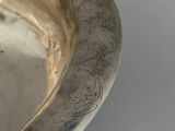 an antique silver plate with a decorative design on the rim
