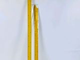 une règle jaune sur fond blanc, à côté d'un mur blanc