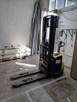 a forklift in the middle of a room with a lot of pallets