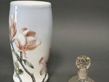 un petit vase et une petite bouteille en verre posés sur une table
