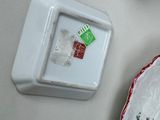 a plate with a tea bag on it next to a tea pot
