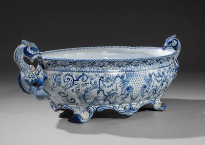 un bol bleu et blanc richement décoré, sur lequel figurent deux oiseaux