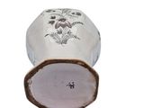 a white vase with a floral design on it