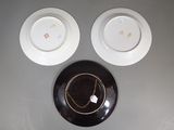 three plates on the table with a clock on the wall