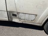 a white car that has a hole in the side of it