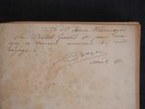 an old book with writing on it sitting on a table