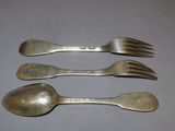 four forks and spoons are lined up on a table