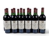 six bottles of red wine lined up in a row on a white surface
