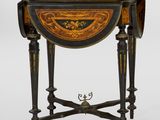 une petite table dont le plateau est orné d'un motif noir et or