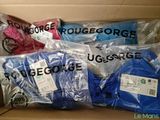 boxes filled with blue, pink, and white shirts and tags on them