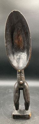 a silver spoon sitting on top of a metal stand
