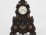 a black and gold clock sitting on a white surface