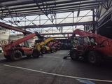 a red crane that is sitting in the middle of a parking lot