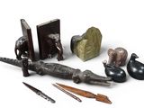 a group of objects that include an alligator, a bookend, a pencil, and a pair of scissors