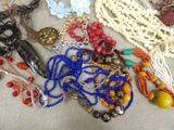 a lot of beads and necklaces laid out on a table
