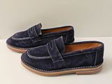 une paire de mocassins en daim bleu pour homme posés sur un fond blanc