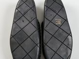 pair of black slippers on a white surface with a white background