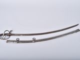 pair of silver plated swords on a white background