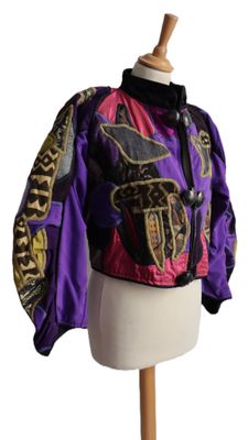 purple and black jacket on a mannequin stand with a white background
